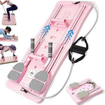 Pink foldable Mini Pilates Reformer with resistance bands and footpads for core strength and flexibility exercises.