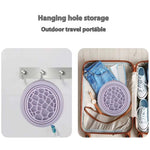 Collapsible purple silicone face bowl with built-in ice tray hanging on hook and packed in suitcase for travel